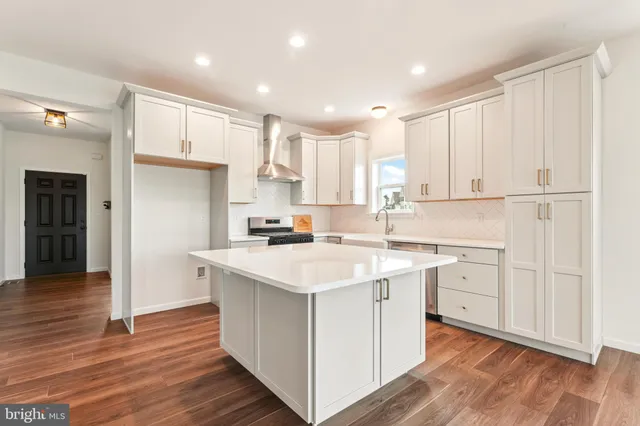 a kitchen with white cabinets appliances and sink
