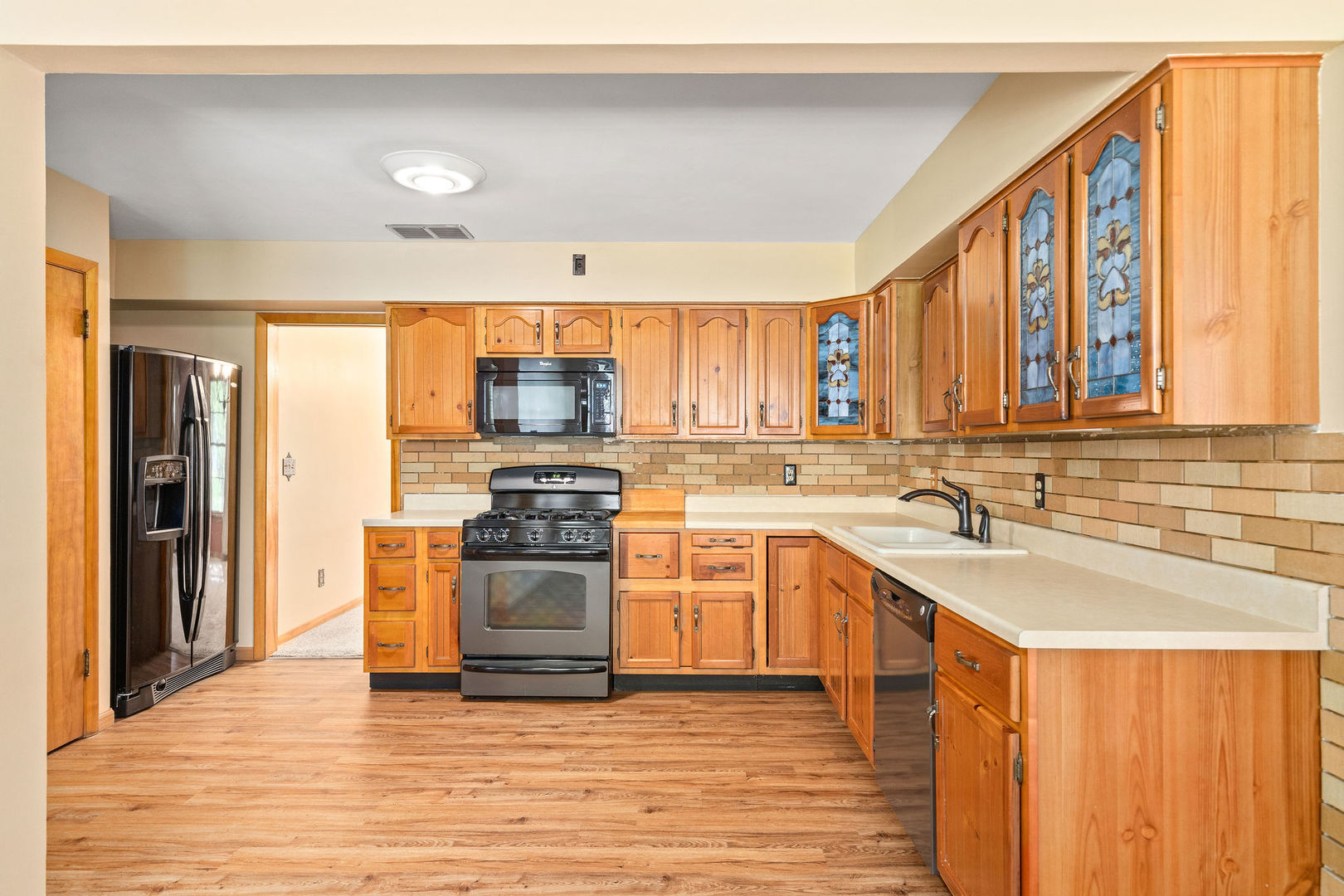 202 Sears Street Plano, IL 60545 - Photo 9 of 32 a kitchen with stainless steel appliances granite countertop a stove a sink and a refrigerator
