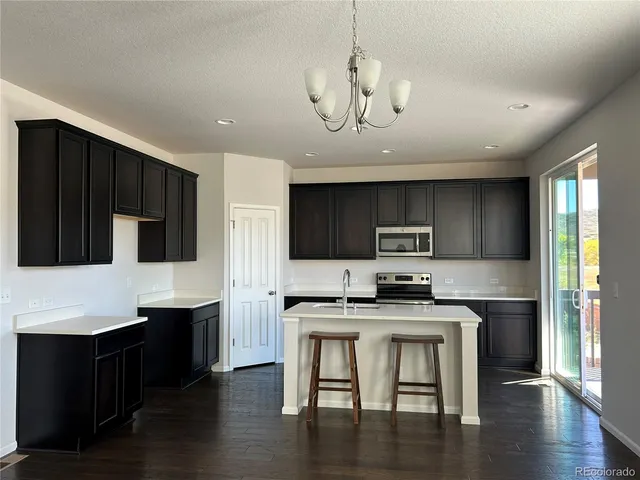 a kitchen with stainless steel appliances a stove top oven a sink and cabinets