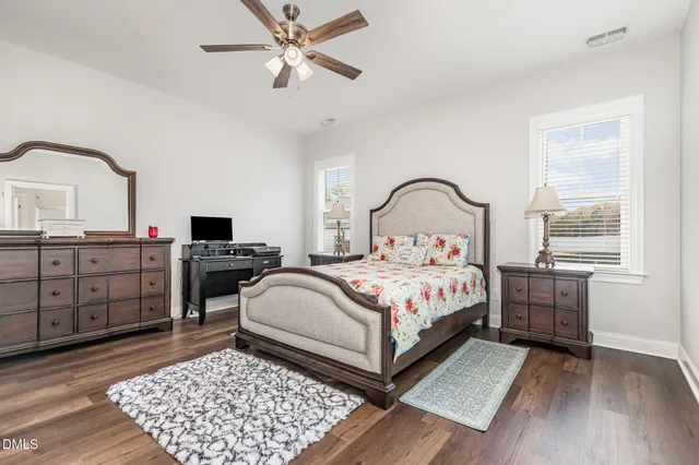 a view of dining room and livingroom with furniture wooden floor a rug a flat screen tv a rug and a chandelier