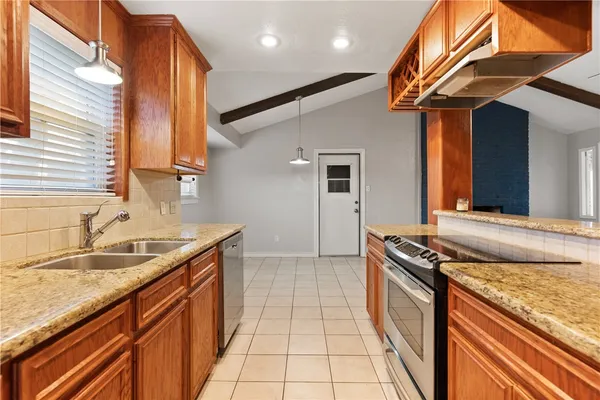 a kitchen with stainless steel appliances granite countertop a sink stove and cabinets