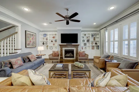 a living room with furniture a fireplace and a flat screen tv