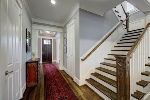 a view of a hallway that has a dining table and chairs
