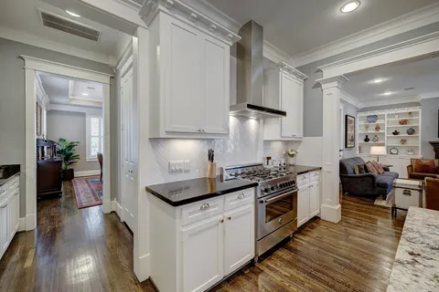 a kitchen with cabinets a sink a stove a dining table and chairs