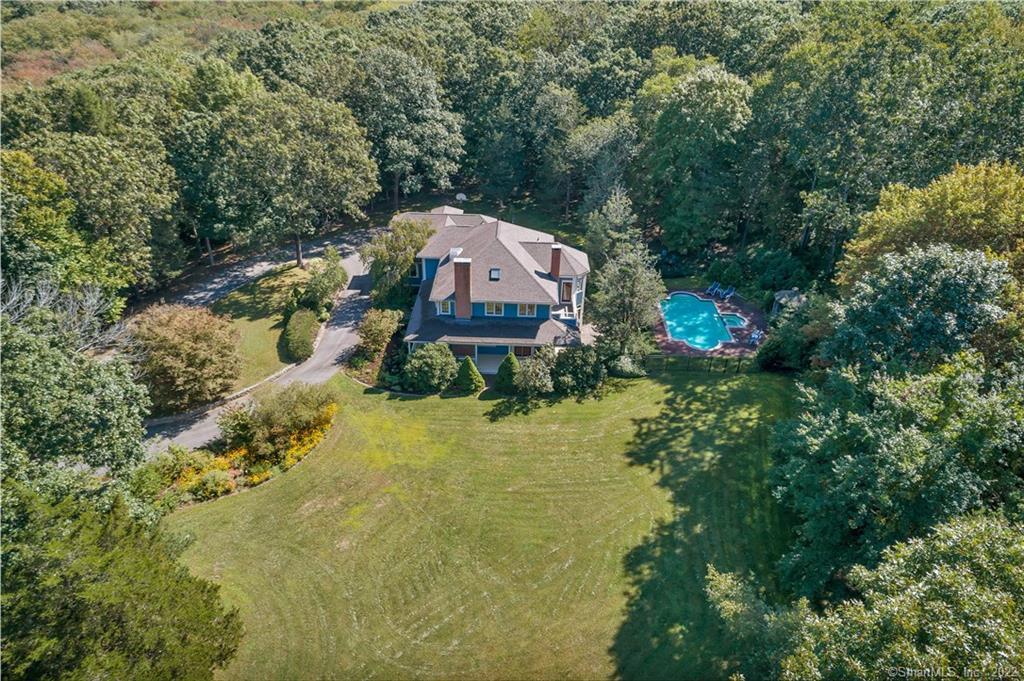 a aerial view of a house with a big yard and large trees