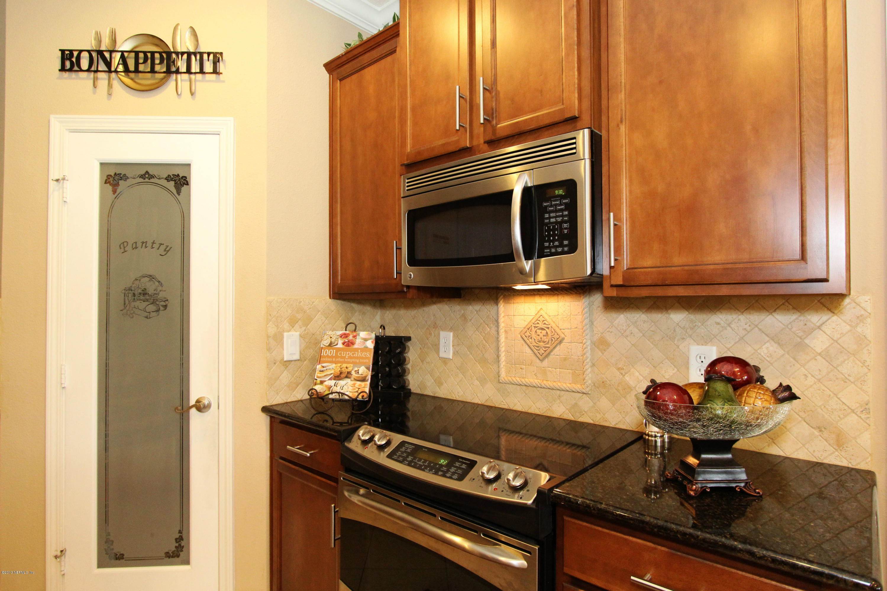 732 Castledale Court Jacksonville, FL 32259 - Photo 21 of 50 a kitchen with stainless steel appliances a stove a microwave and cabinets