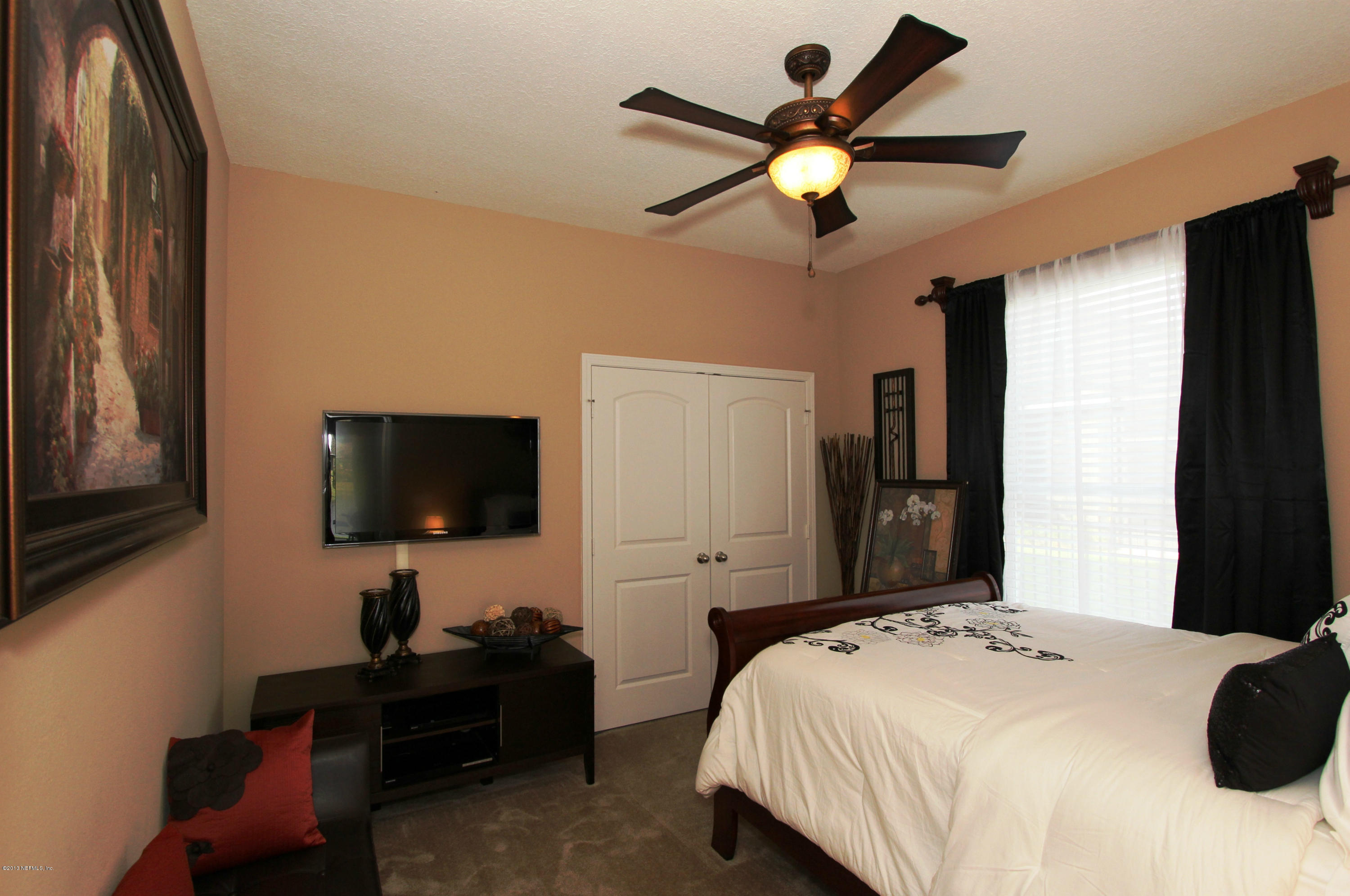 732 Castledale Court Jacksonville, FL 32259 - Photo 30 of 50 a bedroom with a bed window and a flat screen tv