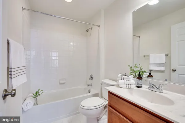 a bathroom with a granite countertop sink a toilet and shower