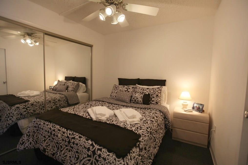 111 South 16th Avenue, Unit 312 Longport, NJ 08403 - Photo 13 of 14 a bedroom with a bed and a chandelier