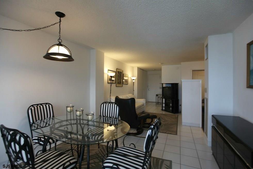111 South 16th Avenue, Unit 312 Longport, NJ 08403 - Photo 5 of 14 a dining room with furniture a chandelier and wooden floor