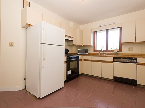 253 Sycamore Street, Unit 253 Watertown, MA 02472 - Photo 12 of 16 a kitchen with white cabinets and white appliances