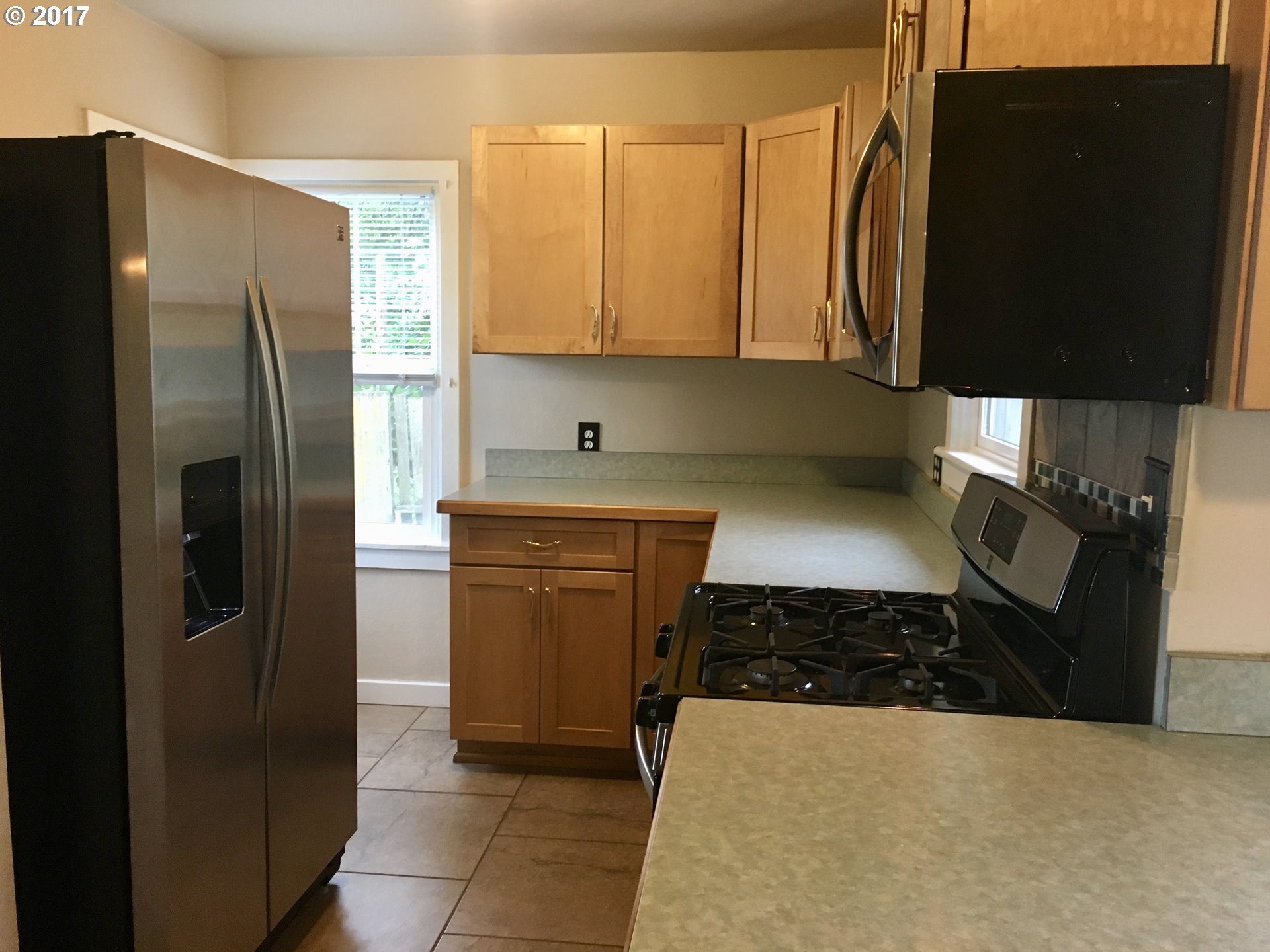 918 Southwest Goodwin Place Pendleton, OR 97801 - Photo 8 of 19 a kitchen with a sink a refrigerator and cabinets