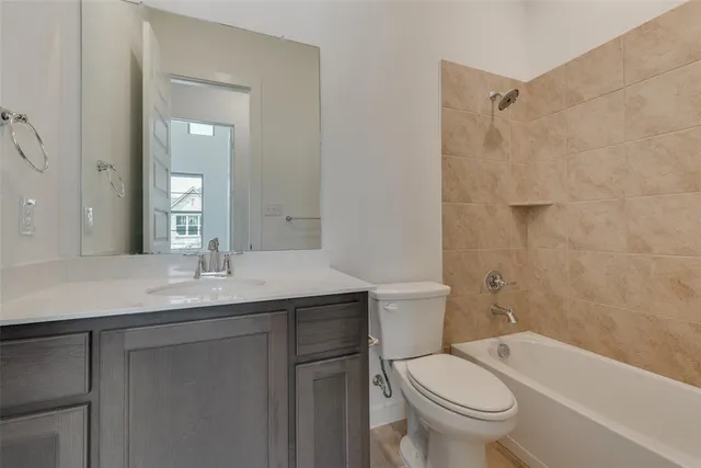 a bathroom with a granite countertop toilet a sink and a bathtub