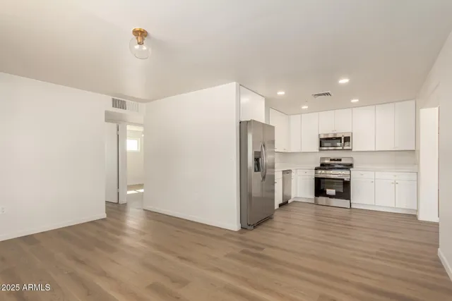 a kitchen with stainless steel appliances a refrigerator and a stove top oven