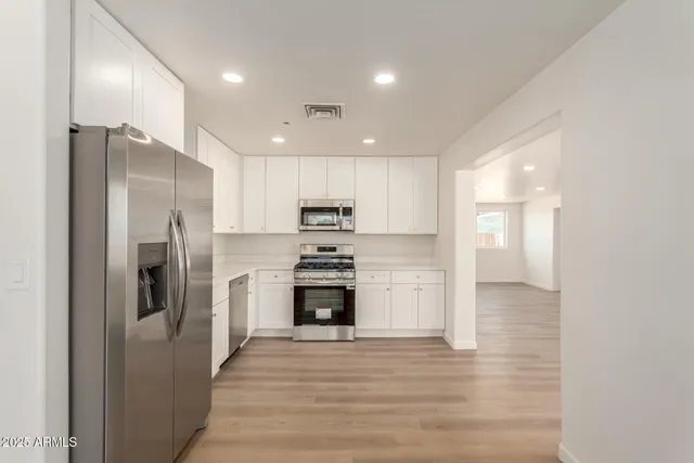 a kitchen with stainless steel appliances a refrigerator sink and microwave
