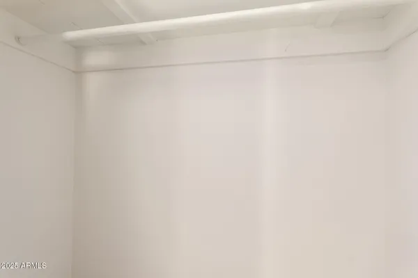 an empty room with a window and a ceiling fan