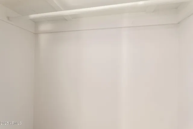 an empty room with a window and a ceiling fan