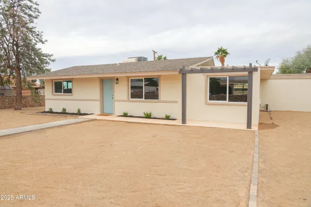 a view of a house with a yard and potted plants