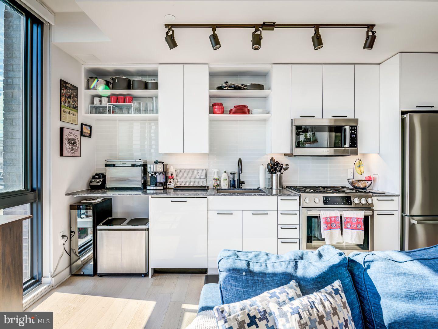 70 N Street Southeast, Unit N811 Washington, DC 20003 - Photo 15 of 28 a kitchen with stainless steel appliances granite countertop a stove a sink dishwasher and a refrigerator with wooden cabinets