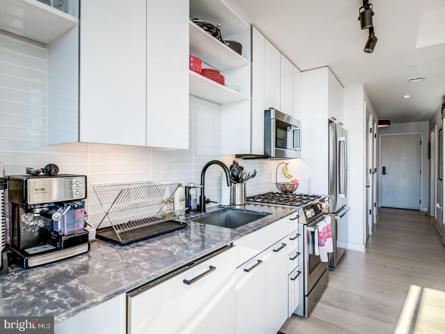 70 N Street Southeast, Unit N811 Washington, DC 20003 - Photo 6 of 28 a kitchen with stainless steel appliances granite countertop a sink stove and refrigerator