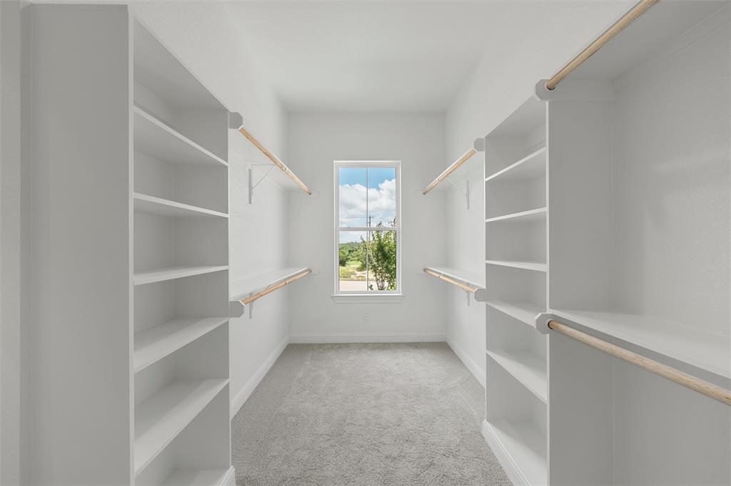 20 Ritchie Road Woodway, TX 76712 - Photo 18 of 40 Walk-in closet with carpet flooring, built-in shelving, and wood-finish hanging rods