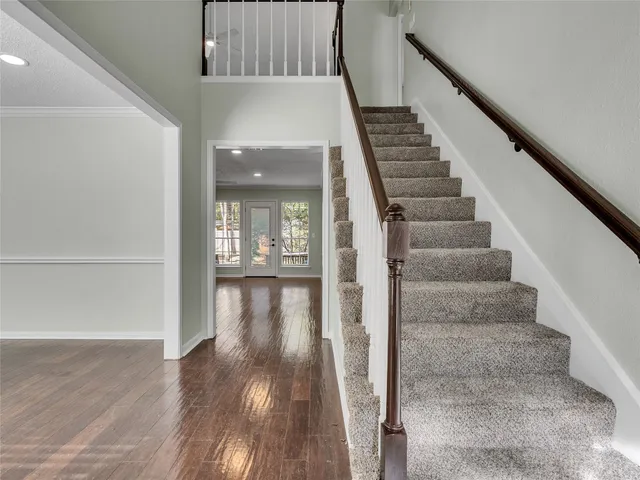 a view of staircase with wooden floor and white walls