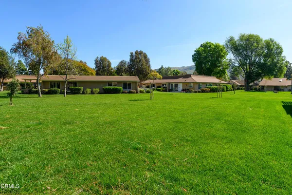 a view of a house with a yard and sitting area