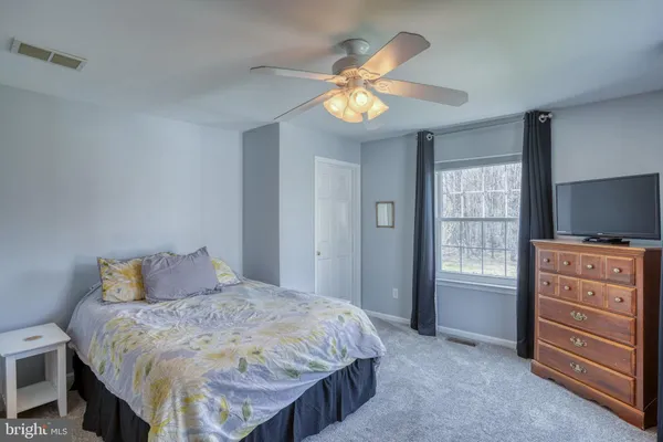 a bedroom with a bed and a flat tv screen on a dresser