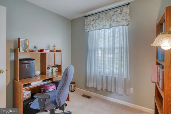 a view of a workspace with furniture and a window