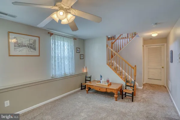 a view of a room with wooden floor and a ceiling fan