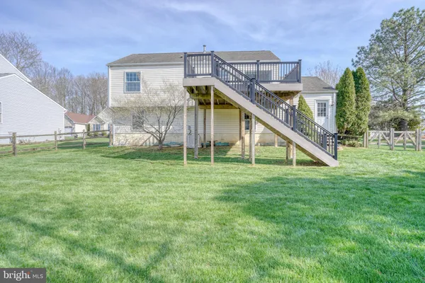 a view of an house with backyard and deck