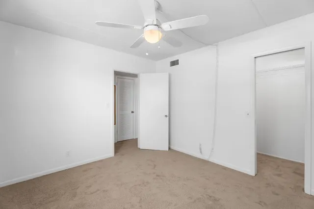 an empty room with a ceiling fan and a fan