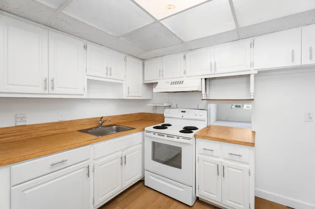 a kitchen with white cabinets and white appliances
