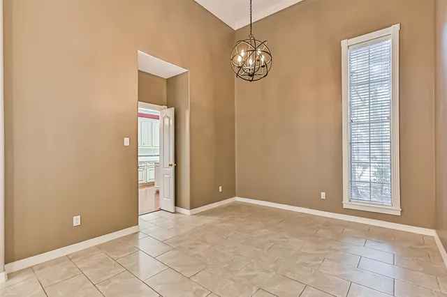 an empty room with chandelier and windows
