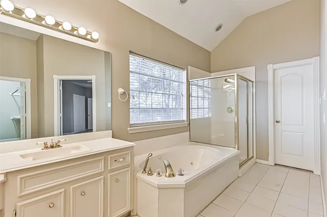 a bathroom with a tub a sink and mirror