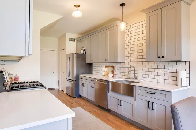 a kitchen with stainless steel appliances a refrigerator sink and cabinets