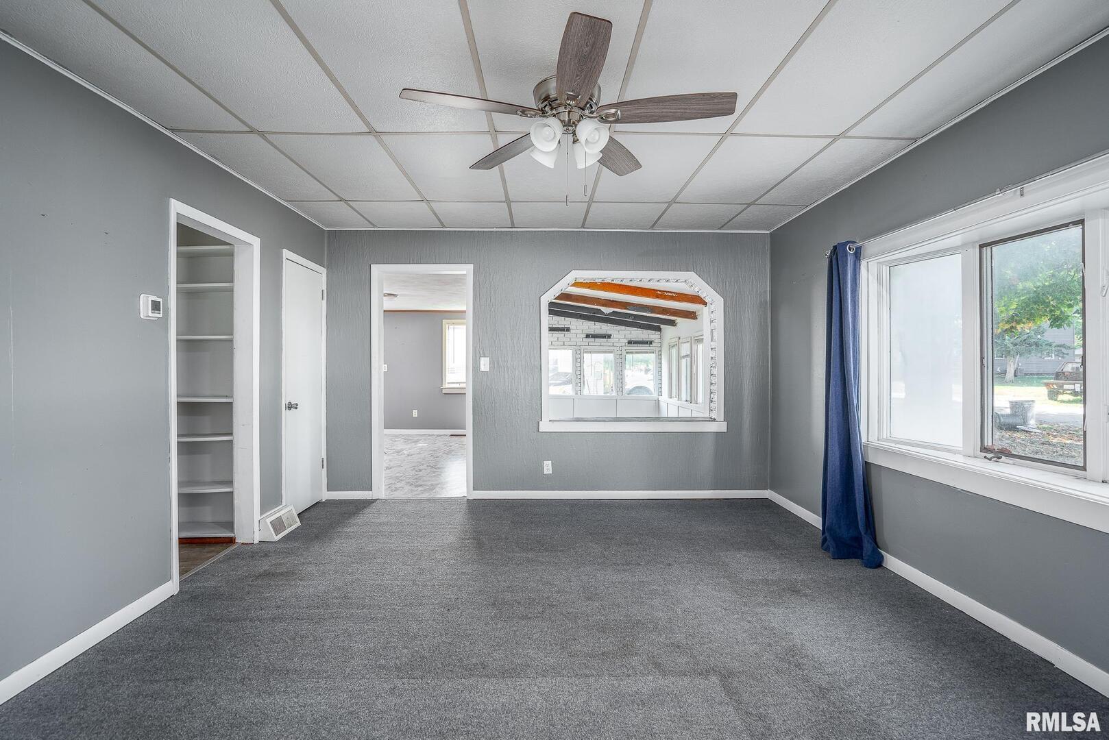516 North Williams Street Reynolds, IL 61279 - Photo 13 of 17 an empty room with windows and chandelier fan