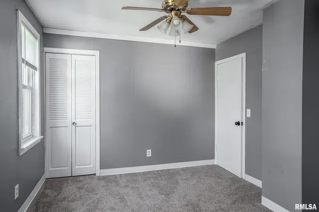 an empty room with a window and a fan