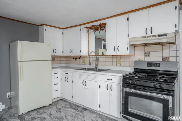 a kitchen with appliances a sink and cabinets
