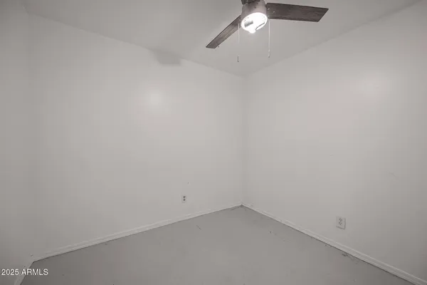 an empty room with a ceiling fan and window
