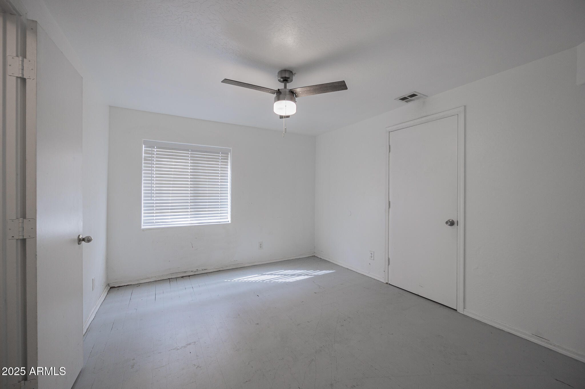 212 North 21st Avenue, Unit 4 Phoenix, AZ 85009 - Photo 12 of 15 an empty room with a window and ceiling fan