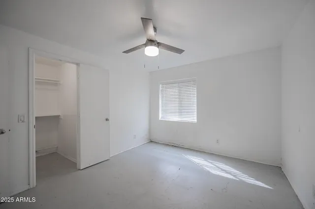 an empty room with a empty space and a ceiling fan