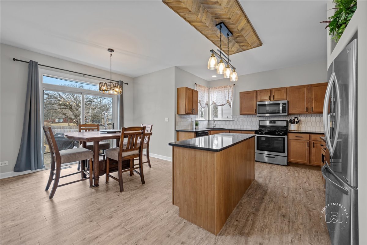 2924 Bauer Road North Aurora, IL 60542 - Photo 12 of 33 a kitchen with stainless steel appliances granite countertop a stove top oven a sink dishwasher a dining table and chairs with wooden floor