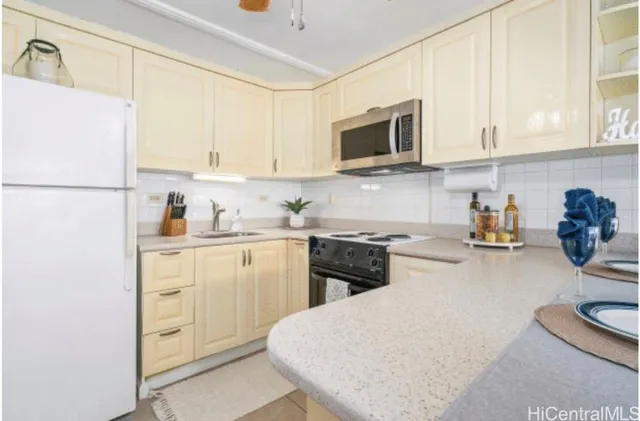 a kitchen with stainless steel appliances white cabinets and a refrigerator