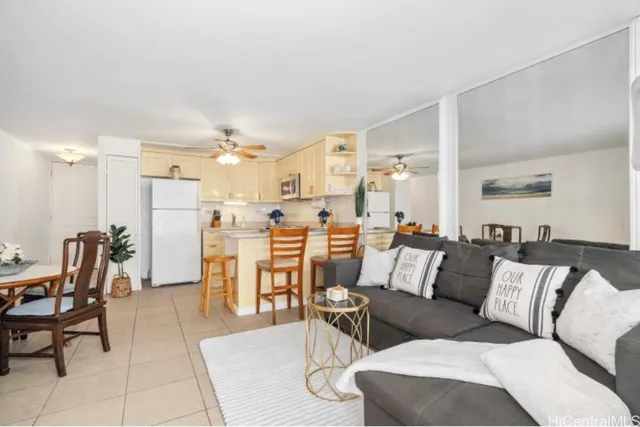 a living room with furniture and a dining table with kitchen appliances