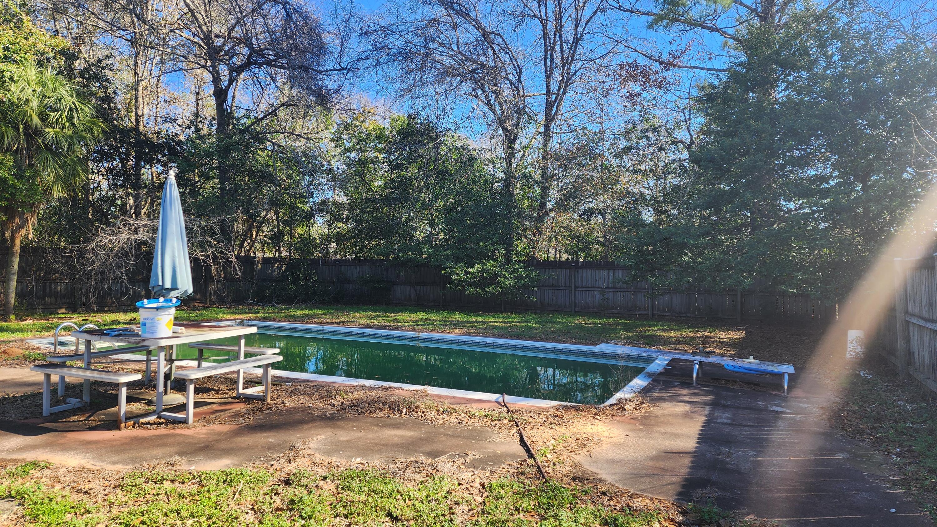 6127 Barnes Road Crestview, FL 32536 - Photo 1 of 16 a view of a lake with a bench and trees