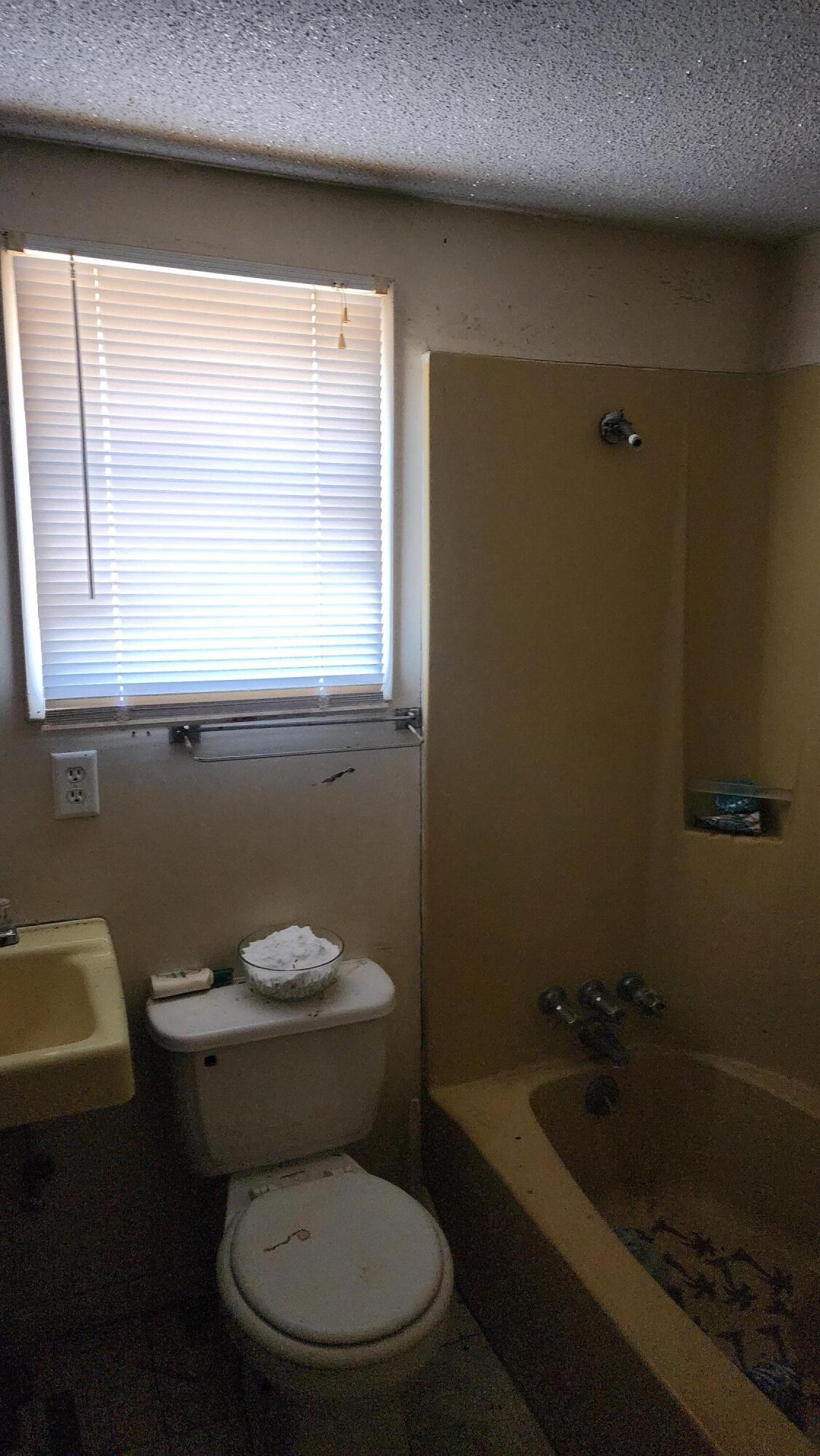 6127 Barnes Road Crestview, FL 32536 - Photo 15 of 16 a white toilet sitting in a bathroom next to a window