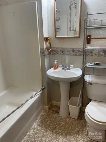 a bathroom with a sink toilet and mirror