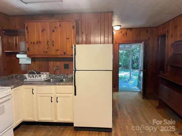 a kitchen with a refrigerator a stove and wooden cabinets