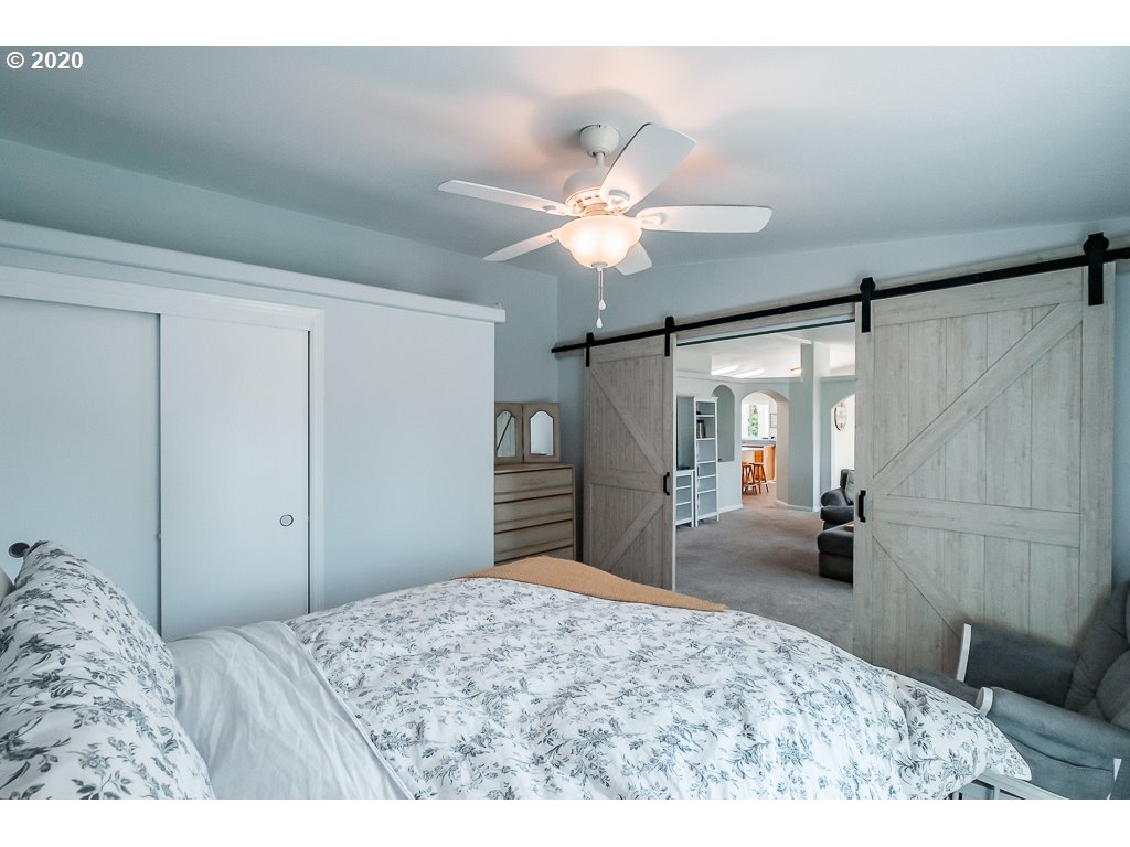 34148 Southeast Jarl Road Boring, OR 97009 - Photo 21 of 32 a bedroom with a bed and a chandelier